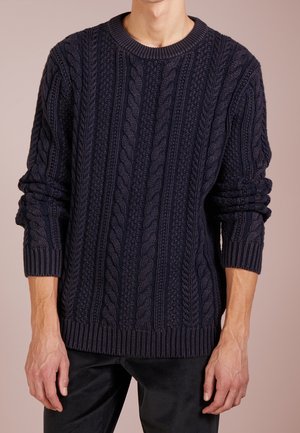 Dunkelblauer Strickpullover mit Zopfmustern, Rundhalsausschnitt sowie gerippten Bündchen und Saum. Hergestellt aus einem dicken, strukturierten Material.