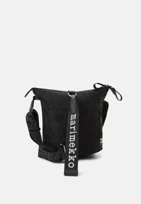 Black fabric bag featuring a floral pattern, with a zip closure and an adjustable strap labeled "marimekko." Rounded shape with soft texture.