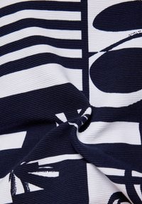 Navy and white patterned fabric featuring bold geometric shapes and textured ribbed design, showcasing alternating stripes and abstract forms.