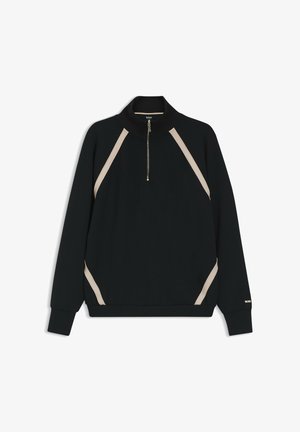 Sweatshirt noir à col montant, avec des rayures diagonales crème le long des épaules et une fermeture éclair à l'avant. Tissu doux et texturé.