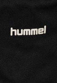Schwarzer Stoff mit glatter Textur, der ein auffälliges weißes "hummel"-Logo in einer modernen Schriftart zeigt, mittig positioniert.