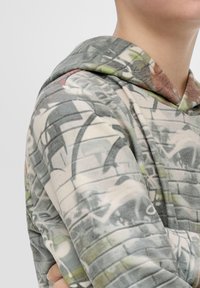Hoodie in zachte, lichtgrijze stof met een grafische print van abstracte vormen en gedempte kleuren. Textuurmateriaal met een relaxte pasvorm.