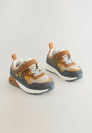 Kinderschuhe mit Sneakers in Braun, Beige und Oliv, aus gemischten Materialien mit strukturierten Oberflächen, weißer gesprenkelter Sohle und verstellbarem Klettverschluss.
