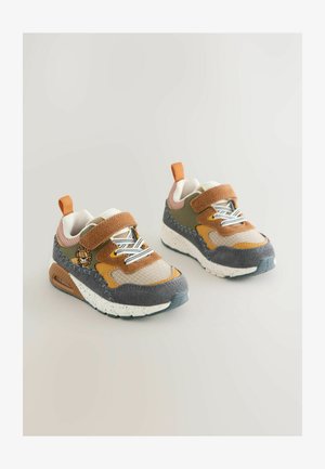 Laste spordijalanõud segamaterjalidest pruuni, beeži ja oliivroheline tooni, tekstuursete pindade, valge täpikaga tallaga ja reguleeritava takjakinnitusega.