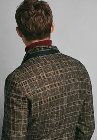 Blazer a quadri con toni marroni e beige, realizzato in tessuto testurizzato, con un colletto blu navy in contrasto e uno strato interno a costine bordeaux.