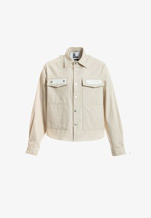Chaqueta beige de manga larga con cierre de botones en la parte delantera, dos bolsillos en el pecho con solapa y cierre de presión, y un cuello puntiagudo.