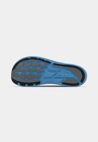 Semelle extérieure de chaussure de course bleue avec un motif texturé, des sections en caoutchouc noir pour la traction, et un design élancé et contourné pour l'adhérence et la durabilité.