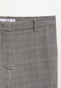 Pantalon taille haute avec motif à carreaux noir et blanc et poches latérales, étiqueté taille EUR S, USA 4, MEX CH par Mango Casual.