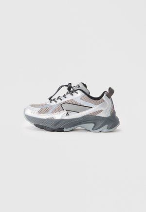 Silberner Sportschuh mit einem Obermaterial aus Mesh, grauer Gummisohle und schwarzen Akzenten. Verfügt über ein Schnürsystem und strukturierte Details an der Sohle.