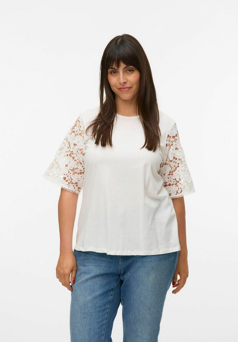Witte t-shirt met korte mouwen van kant, ronde halslijn en een relaxte pasvorm. Het kant heeft bloemmotieven en geschulpte randen.