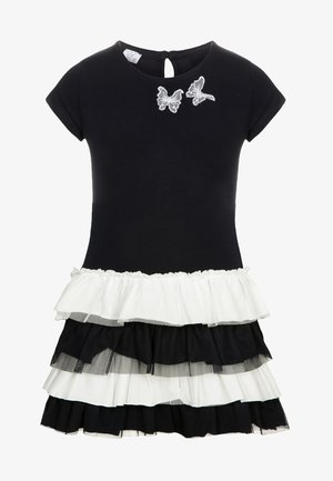 Robe noire à manches courtes avec jupe à volants superposés noire et blanche et deux appliques papillons blanches près de l'encolure.