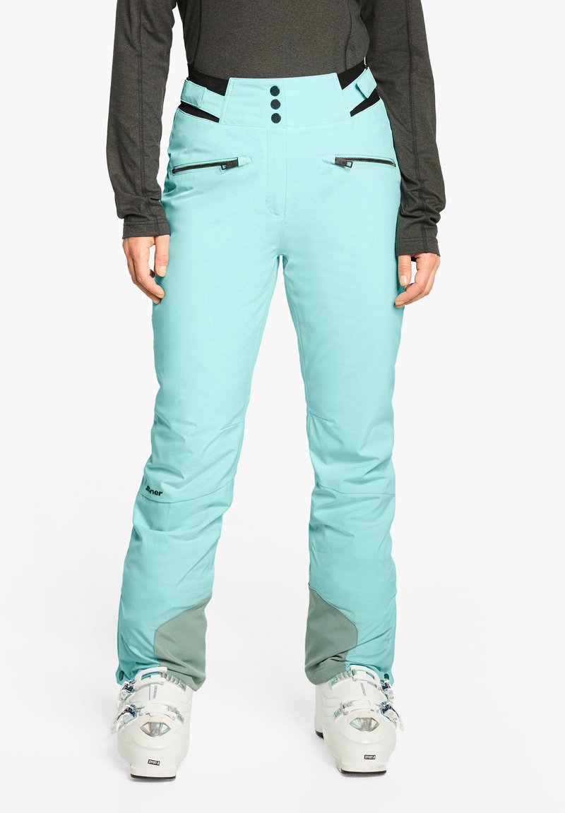 Hellblaue Skihosen mit hohem Bund, mit Reißverschlusstaschen und grauen Akzenten an den Säumen. Hergestellt aus einem glatten, wetterfesten Material.