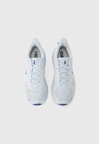 Λευκά αθλητικά παπούτσια με πλεκτή υφή, με μπλε λεπτομέρειες, με κορδόνια και μαλακή σόλα. Θέα από πάνω, μινιμαλιστικό στυλ.