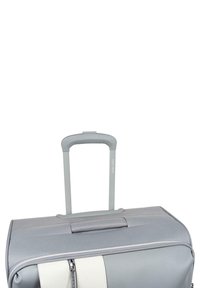 Bolso de viaje gris con mango telescópico, que presenta una textura suave, una franja blanca y un compartimento con cremallera.