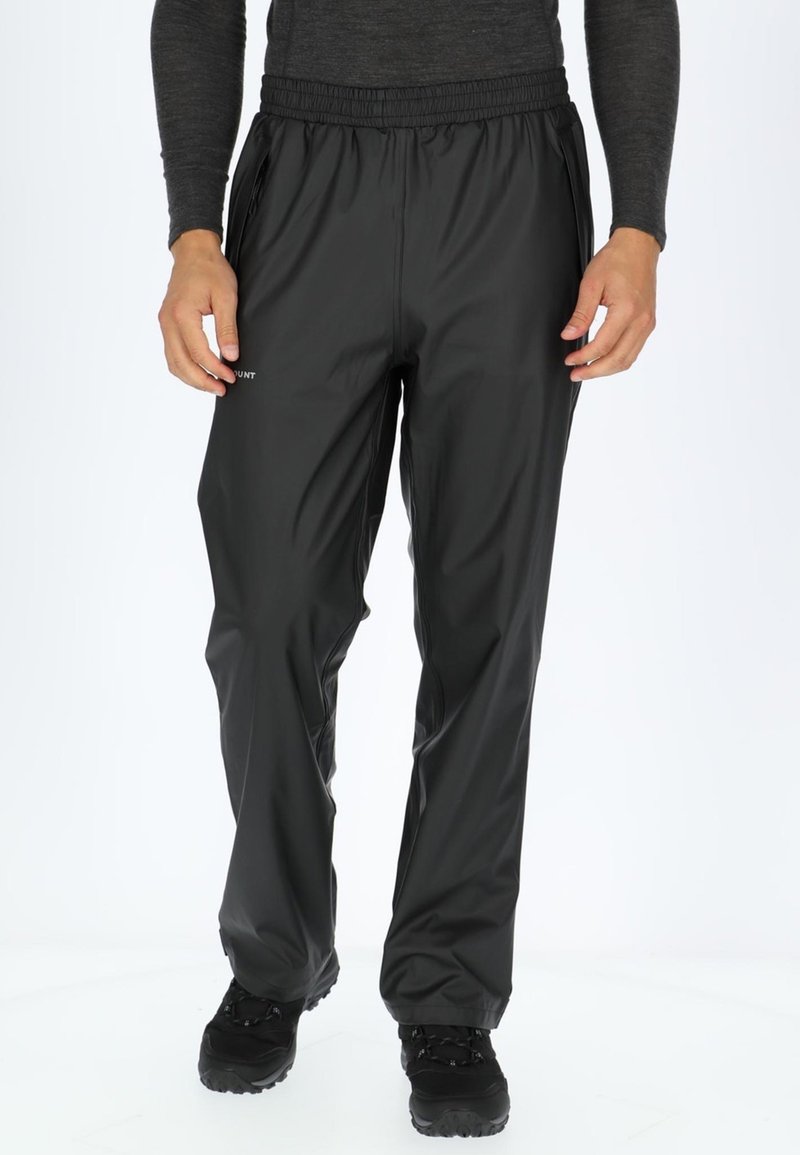Zwarte waterdichte broek met een elastische tailleband, taps toelopende benen en zijzakken met rits, gemaakt van een gladde, lichte stof.