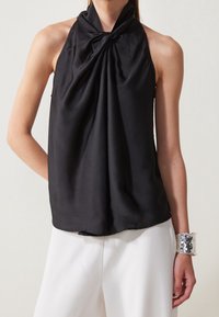 Černý saténový halter top s uzlovým designem na výstřihu, který má hladký povrch a splývavou siluetu.