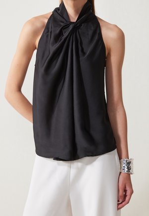 Top halter in satin nero con un design annodato sul collo, caratterizzato da una texture liscia e una silhouette fluida.