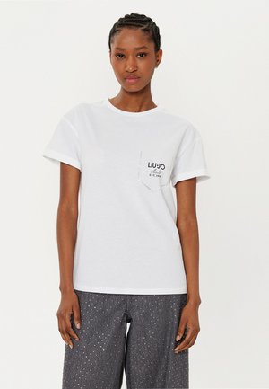 T-shirt bianca in cotone con maniche corte e scollatura rotonda. Presenta una tasca sul petto sinistro con il logo "LIU•JO" e il testo "EST. 1995".