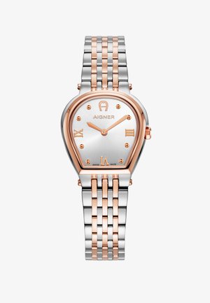 Sidabrinė ir rožinio aukso laikrodžiai su ašaros formos korpusu, romėniškais skaitmenimis ir sujungta metaline apyranke. Apima tekstūruotą sidabro ciferblatą.