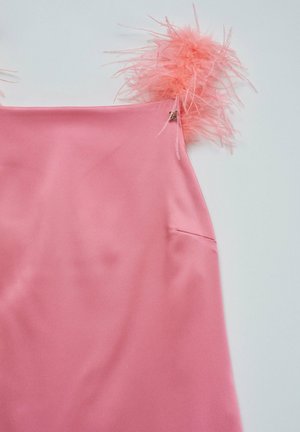 Vestido de satén rosa con acentos de plumas rosas esponjosas en los tirantes y un pequeño bolsillo lateral. Textura suave con un ligero brillo.