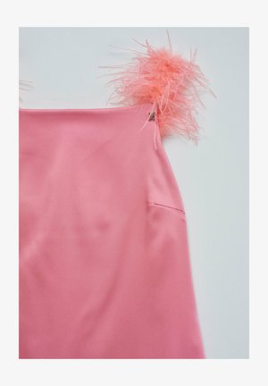 Vestido de satén rosa con acentos de plumas rosas esponjosas en los tirantes y un pequeño bolsillo lateral. Textura suave con un ligero brillo.