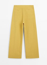 Gele broek met wijde pijpen, hoge taille, vlak voorpand en twee achterzakken met bies, plat neergelegd op een effen witte achtergrond.