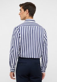 Marineblauwe en witte gestreepte lange mouw shirt met een klassieke kraag, knoopmanchetten en een gladde stoftextuur. De achterkant toont de pasvorm en naaddetails.