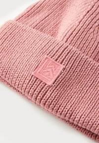 Růžový pletený beanie s ribovanou strukturou a čtvercovou vakou. Vyznačuje se měkkým, teplým materiálem a těsným střihem.