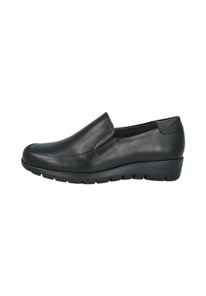 Zapato negro de piel tipo slip-on con tacón de cuña ligero y suela de goma estriada, diseñado para uso casual o formal.