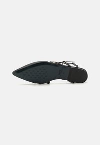 Black sandal with a pointed toe, slender straps, and a textured sole. Features a sleek design and minimal hardware accents.