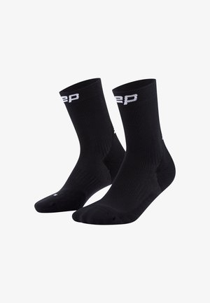 Schwarze Sportsocken mit geripptem Design und weißen Logoakzenten. Knöchelhoch mit verstärkter Zehen- und Fersenpartie für Langlebigkeit.