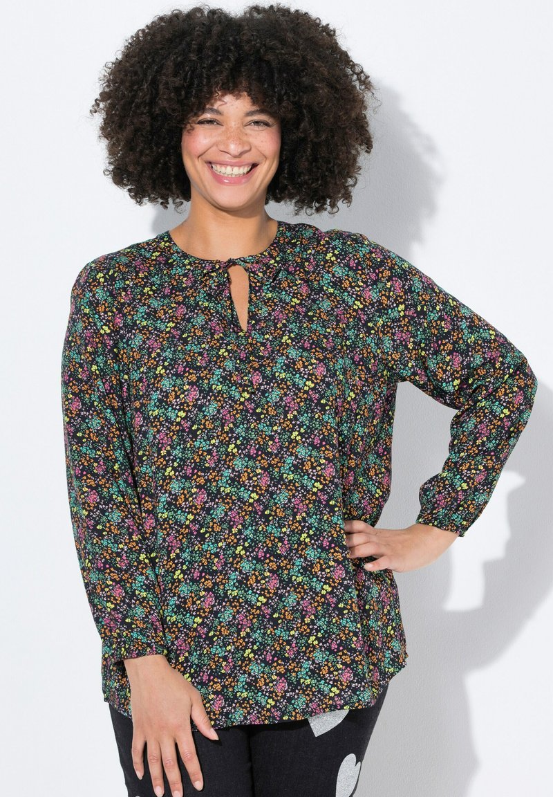 Černá blusa s dlouhými rukávy a květinovým vzorem v růžové, modré a žluté barvě. Výstřih ve tvaru klíčové dírky, měkká tkanina, volný střih.