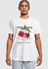 Hvid t-shirt med et grafisk motiv af røde terninger med sorte prikker, tekst i sort og rød samt en grøn bladdetalje. Casual pasform.