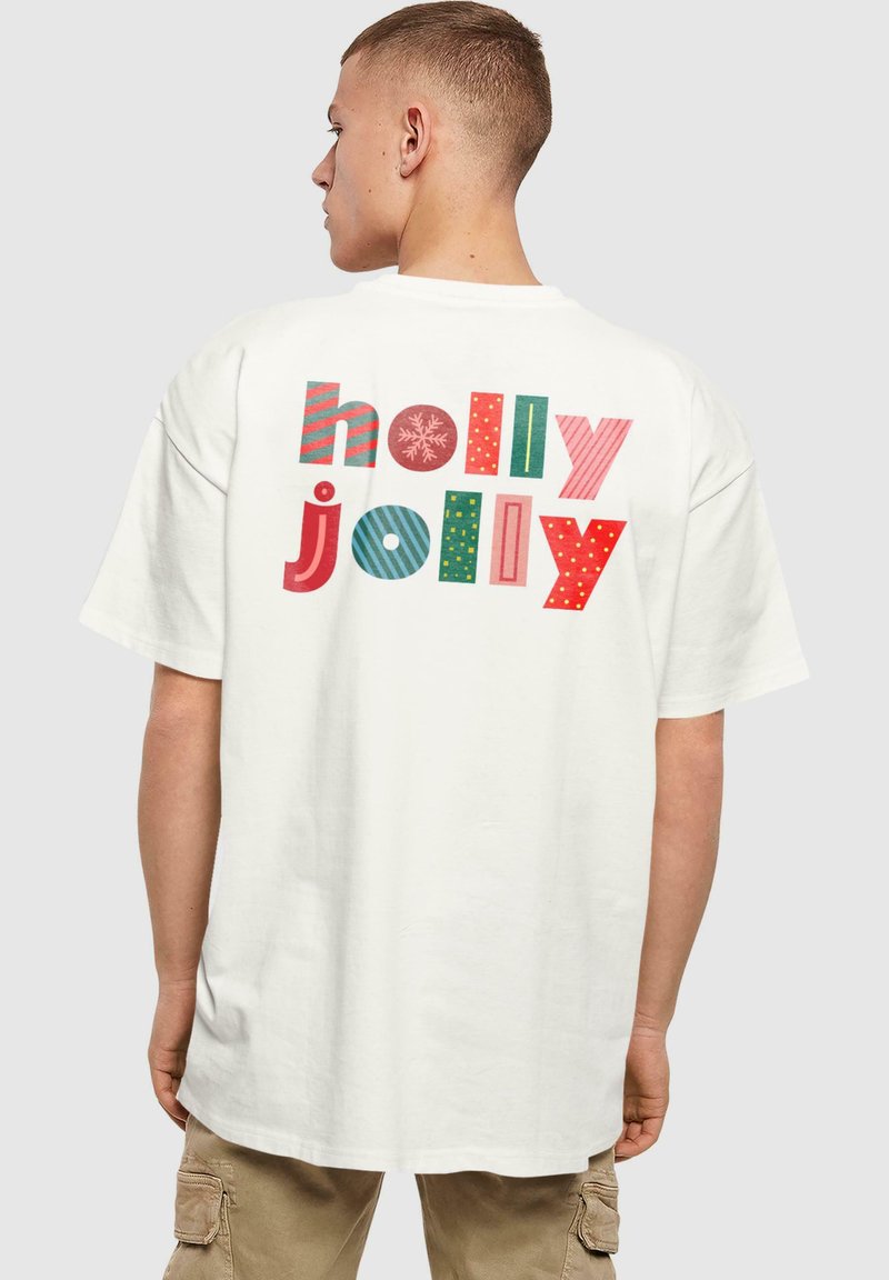 Valkoinen puuvillapaita, jossa on iso, värikäs "holly jolly" -teksti selässä. Suunnittelussa vaihtelevia kuvioita, kuten raitoja ja pisteitä. Lyhyet hihasuet.
