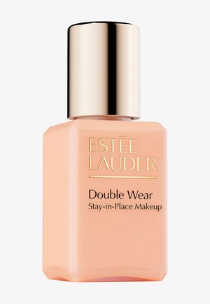 Estée Lauder Double Wear Foundation in einer hell pfirsichfarbenen Glasflasche mit goldenem Metallverschluss und schwarzem Text auf der Vorderseite.