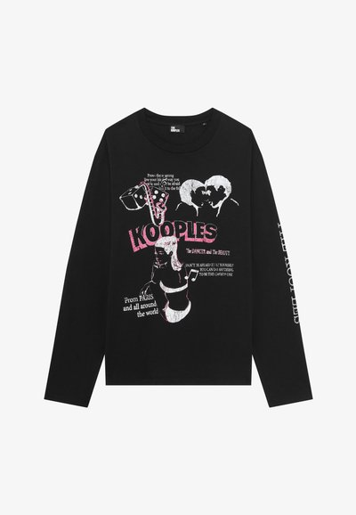 Camisa negra de manga larga con un gráfico en rosa y blanco de dos rostros besándose, una mujer, notas musicales, dados y texto que incluye 'KOOPLES' en letras grandes.