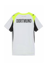 Jersey deportivo blanco con acentos en negro y amarillo neón. "DORTMUND" impreso en negrita negra en la parte posterior. Mangas cortas, material ligero.