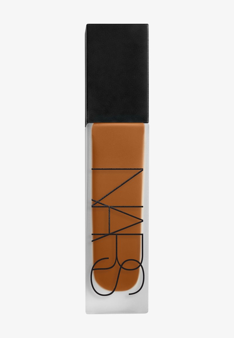 Fond de teint liquide dans un flacon en verre rectangulaire avec un bouchon noir et un texte de marque minimaliste en noir sur fond blanc.