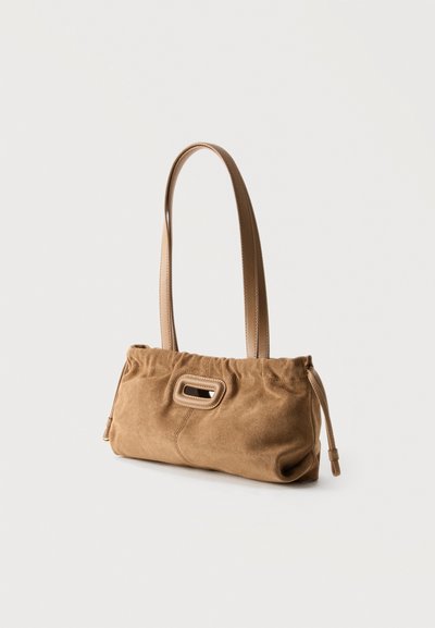 Καφέ τσάντα ώμου από σουέτ με μακριά δερμάτινα λουριά και ορθογώνια λαβή κομμένη σε φωτεινό μονόχρωμο φόντο.