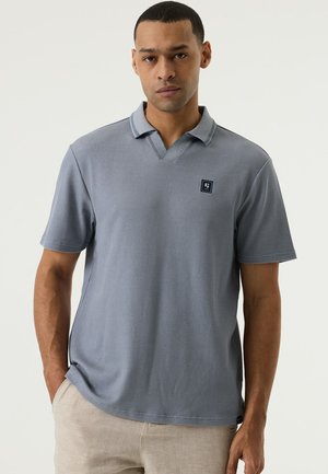 Polo de manga corta con textura en azul claro, con cuello en V, un patrón sutil de canalé y un pequeño logo en el pecho.