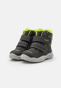Stivali per bambini neri e grigi con accenti verde neon, dotati di due cinturini regolabili in Velcro e una suola testurizzata e resistente.