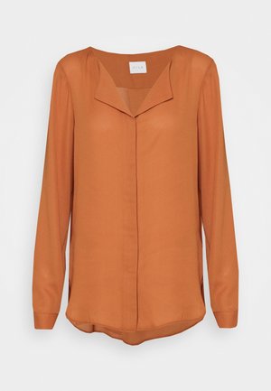 Blusa a maniche lunghe color ruggine con scollo a V, tessuto morbido, chiusura con bottoni e spacchi laterali per una maggiore libertà di movimento.