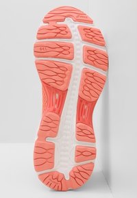 Sole di scarpa da corsa rosa e bianca con motivo di grip testurizzato, caratterizzata da rilievi curvi ed elementi di ammortizzazione strategici. Progettata per comfort e supporto.