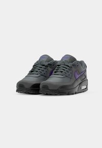 Gray Nike Air Max sneakers with purple accents, featuring a mesh and synthetic upper, visible air cushioning, and textured rubber sole.