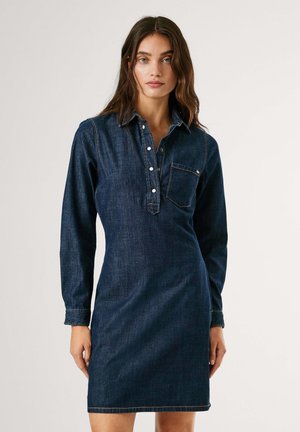 Robe en jean bleu foncé avec un col, des manches longues, un boutonnière sur le devant et une poche poitrine. Détails de couture simples.