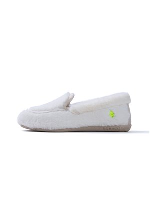 Zapatilla blanca peluda tipo slip-on con suela marrón claro y pequeño icono verde sonriente de aguacate en el lateral, vista desde el lado exterior.