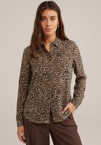 Košile s leopardím potiskem v hnědé a černé barvě, s designem na knoflíky, dlouhými rukávy a límcem. Hladká tkanina s uvolněným střihem.