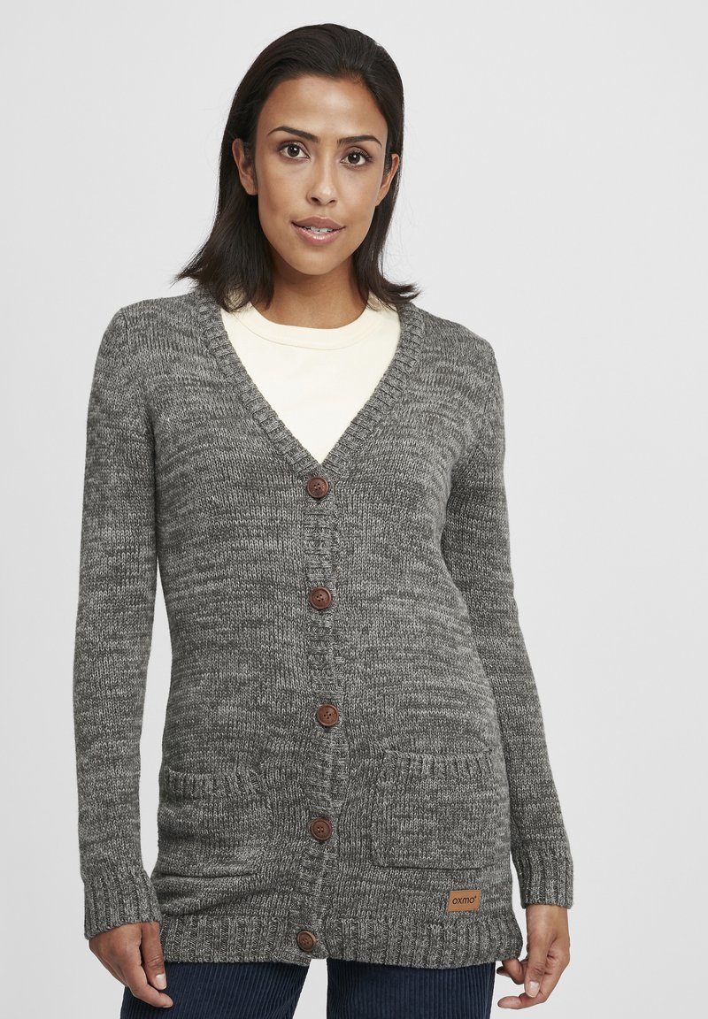 Grauer Strickcardigan mit V-Ausschnitt, langen Ärmeln, fünf braunen Knöpfen, zwei vorderen Taschen und einem kleinen Logo-Patch am Saum.