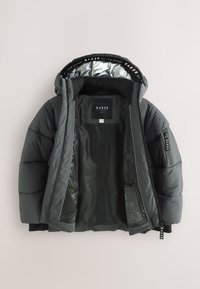 Dark gray padded hooded jacket open to show interior lining and BAKER brand label on collar and inner chest.