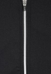 Černá bunda na zip vyrobená z žebrované látky. Má centrální bílý zip a hladkou texturu. Minimalistický design bez dalších vzorů.